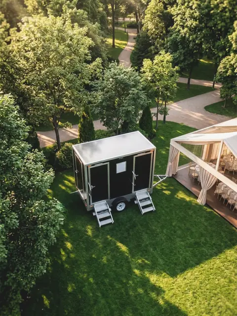 Restroom trailer beside an outdoor event tent
