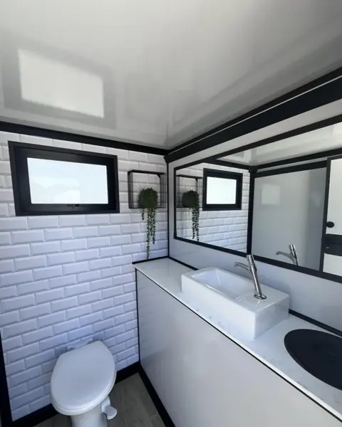 Tiled restroom trailer interior with porcelain toilet