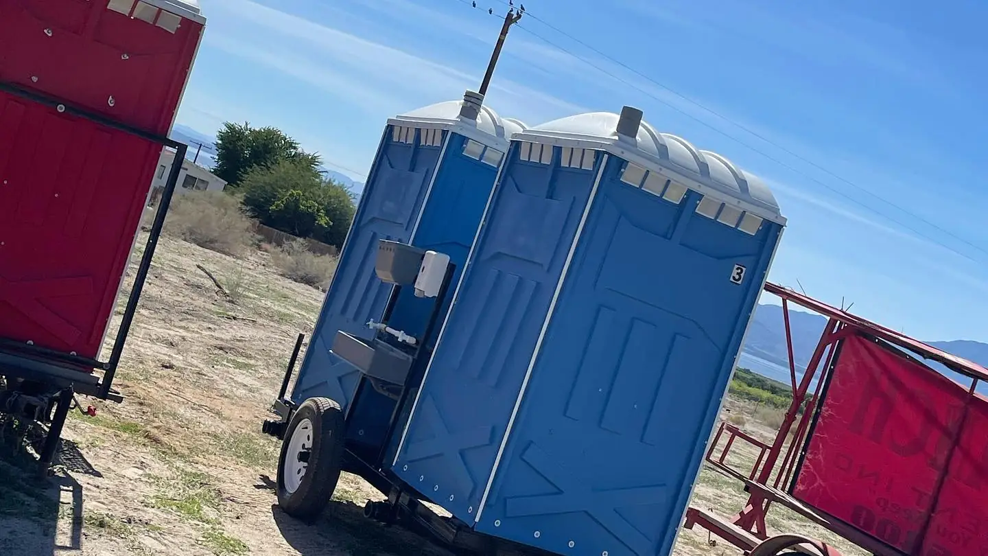 Porta potties on a transport trailer at a field site