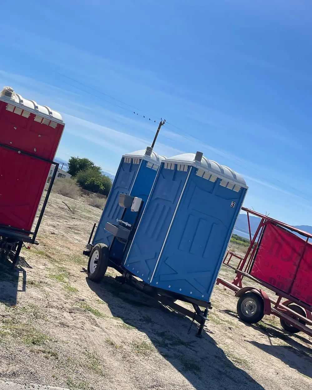 Porta potties on a transport trailer at a field site