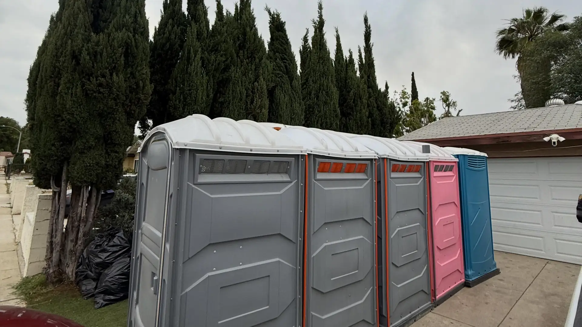 Row of porta potties along a residential lot