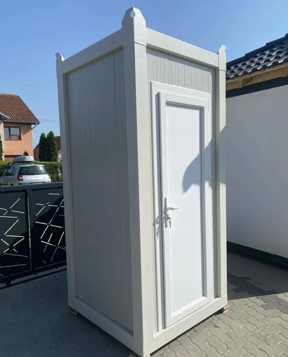 White restroom cabin in a driveway